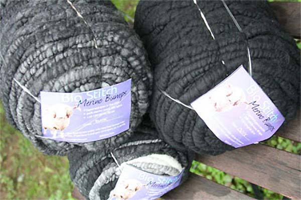 Knitting needles on gray knitted blanket from merino wool, super